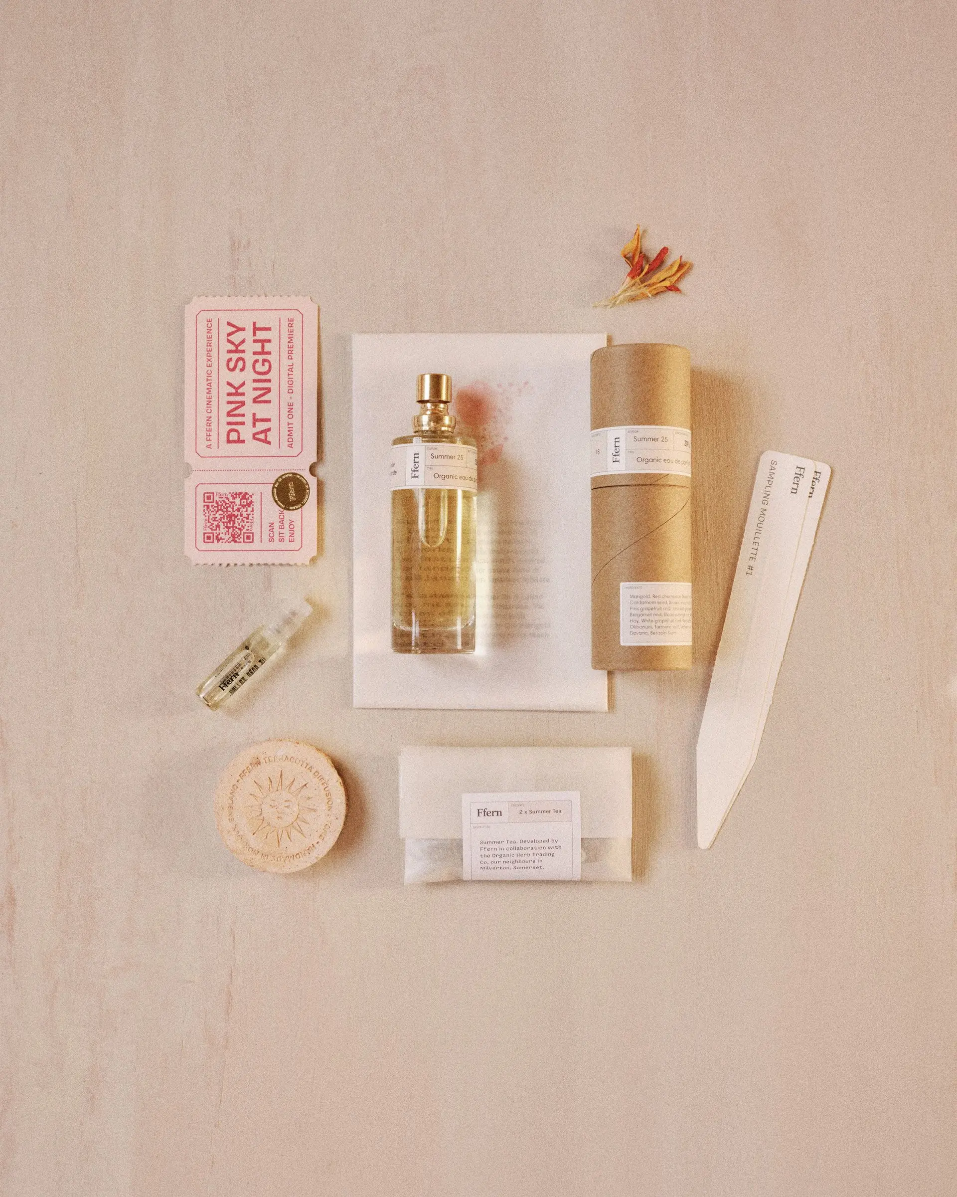 perfume sample vial, full-size bottle, blotter card, and outer carton arranged for a discovery experience