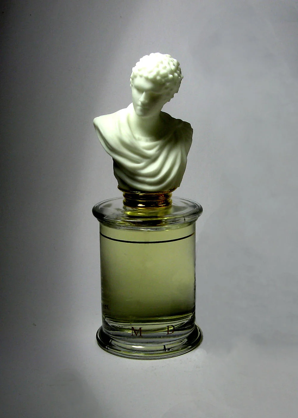 Parfums MDCI cylindrical perfume bottle topped with a white classical bust