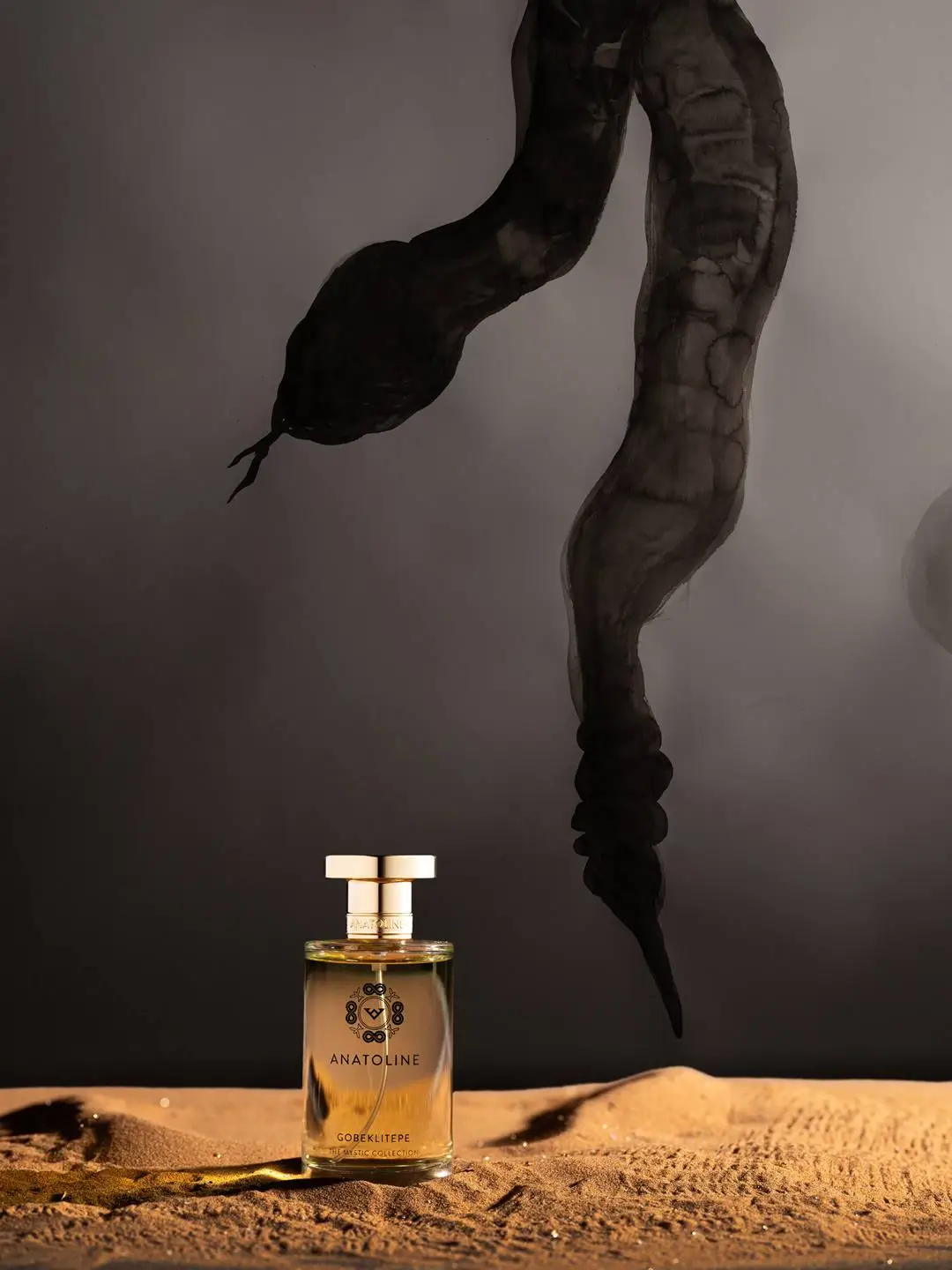 ANATOLINE Gobeklitepe perfume bottle with circular gold-toned upper element and central emblem