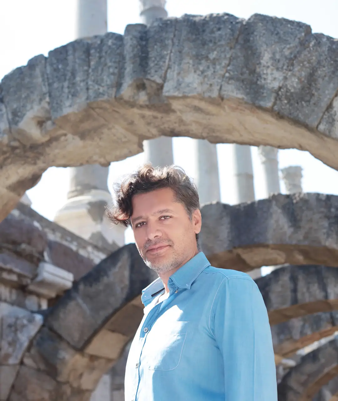 ANATOLINE founder Halil Özer standing among archaeological ruins