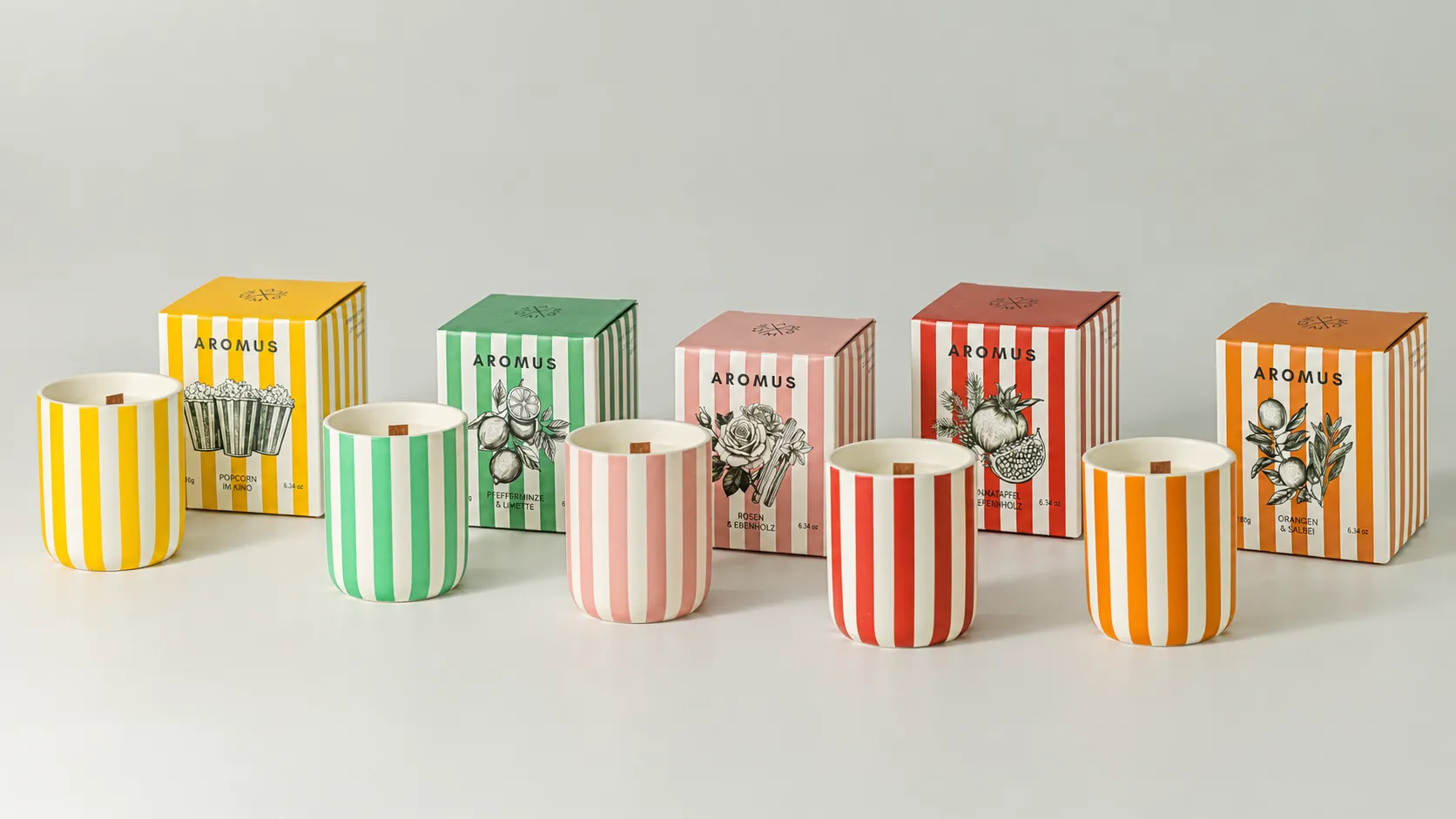 Five striped ceramic candle jars displayed with five matching AROMUS fragrance boxes