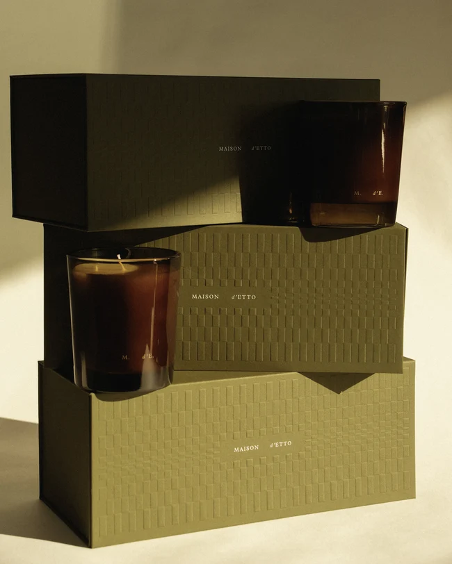 Maison d'Etto dark candle vessels displayed with moss green patterned boxes