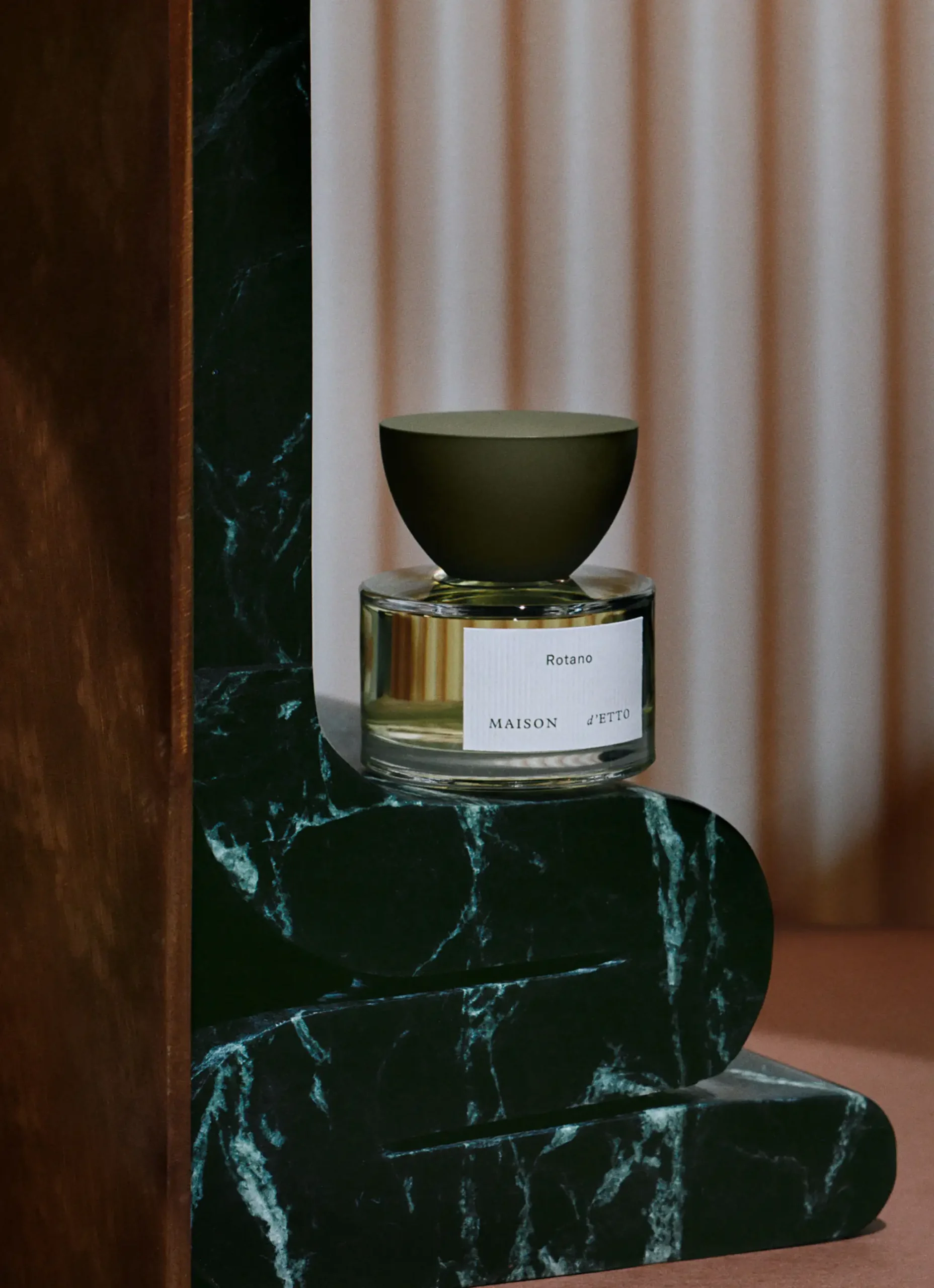 Maison d'Etto perfume bottle and separate dome-like upper element shown in a packaging still life