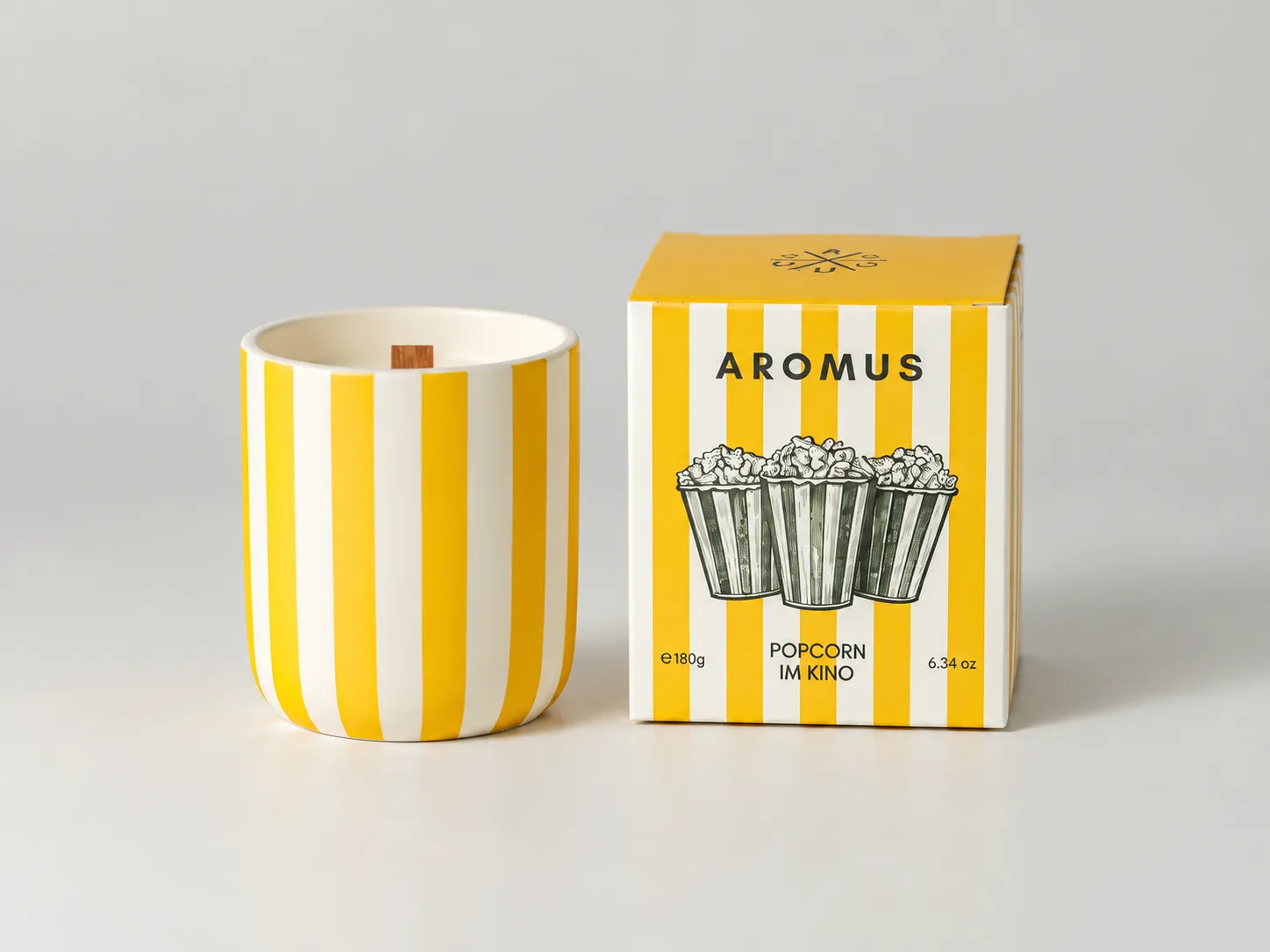 Yellow striped ceramic candle shown beside its matching yellow AROMUS fragrance box